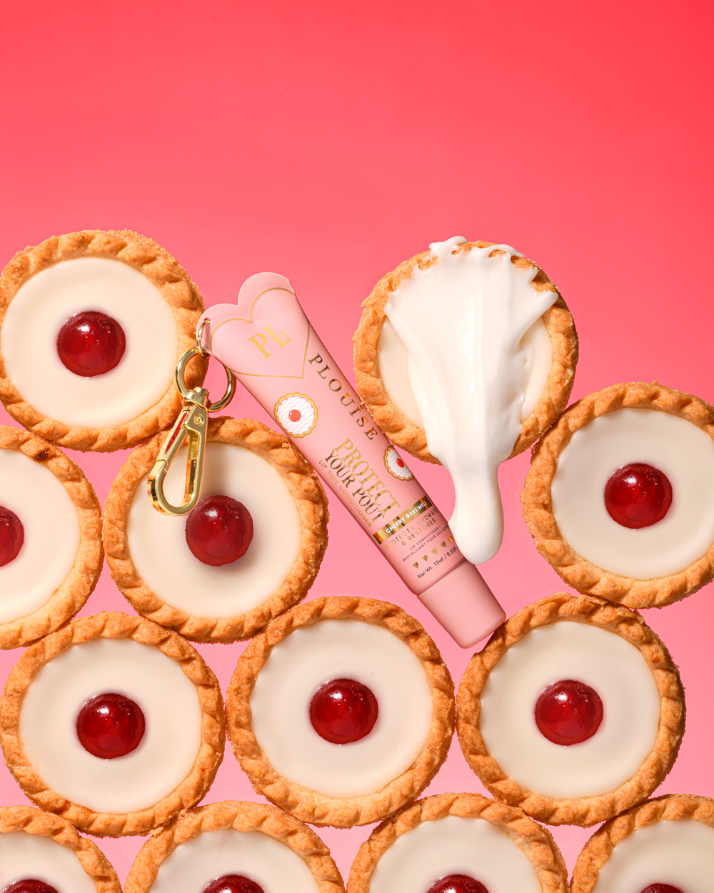 Tónovaný kondicionér na rty s vůní růžových třešní a mandlí chrání vaše našpulené rty se zlatou sponou umístěnou mezi dezerty cherry bakewell