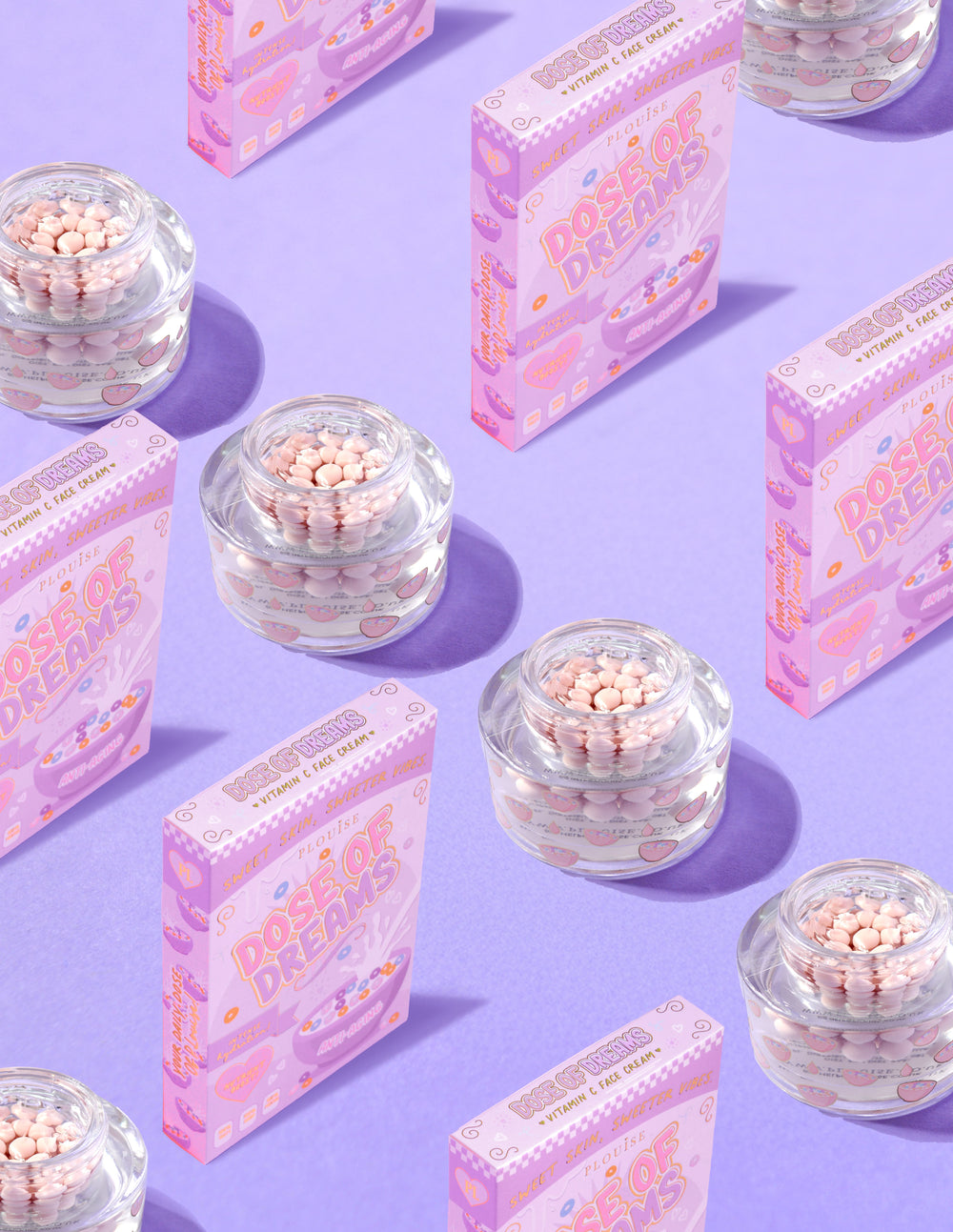 Průhledné nádobky P.Louise DOse of Dreams Viatmin C Capsule Face Cream s růžovými kapslemi v nich obklopenými růžovými cereáliemi na fialovém pozadí