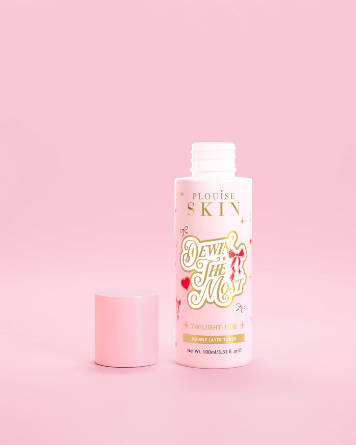 Růžová lahvička P.Louise Dewin The MOst Double Layer Toner s červenou mašlí na růžovém pozadí 