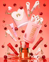 Dárková sada Pink XL Protect Your Pout, která se otevírá obklopená třešněmi a růžovými a červenými kondicionéry na rty na růžovém pozadí
