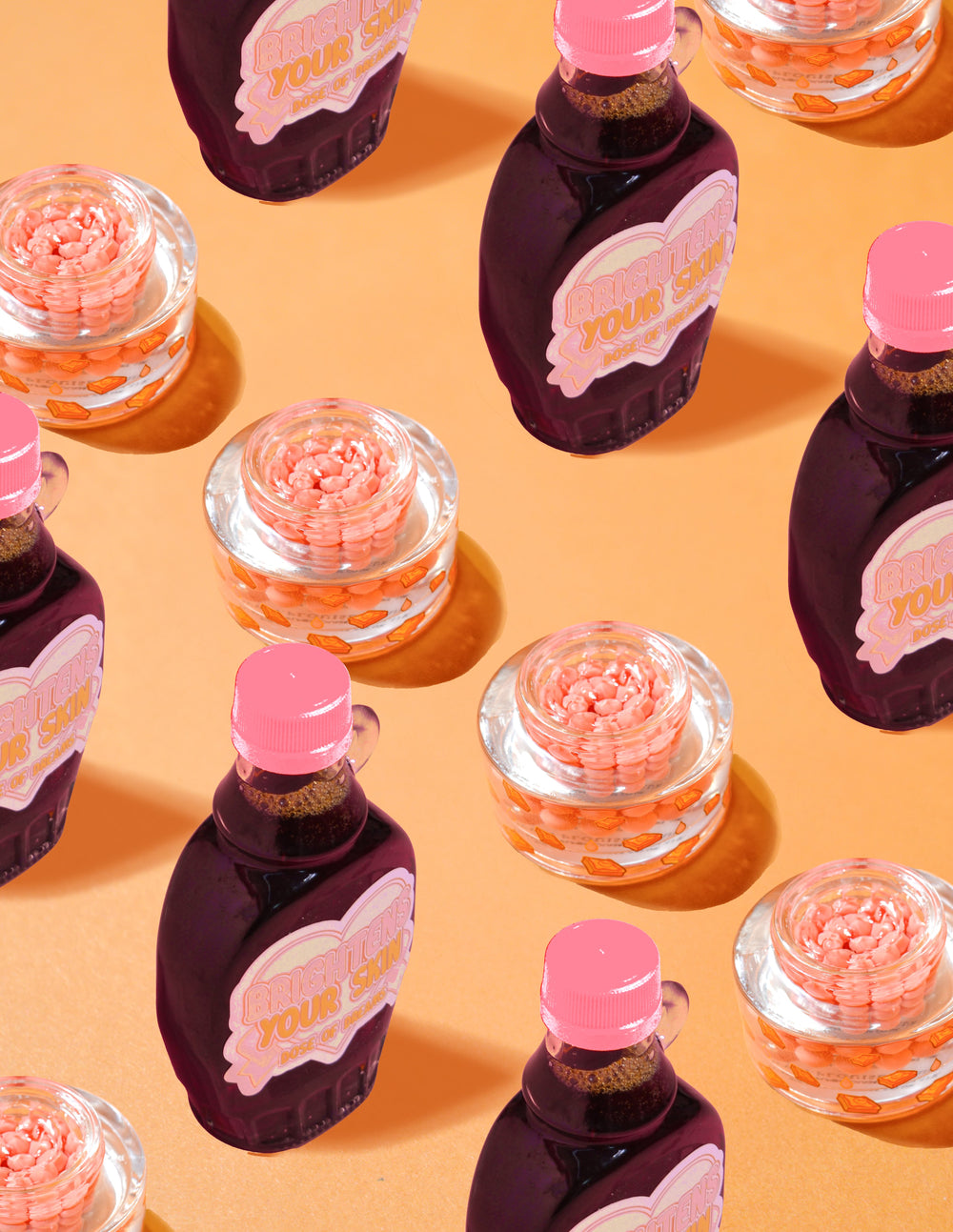 Průhledné nádoby P.Louise Dose of Dreams Vitamin C Capsule Cream s oranžovými kapslemi uvnitř obklopenými fialovými a růžovými lahvičkami se sirupem na oranžovém pozadí