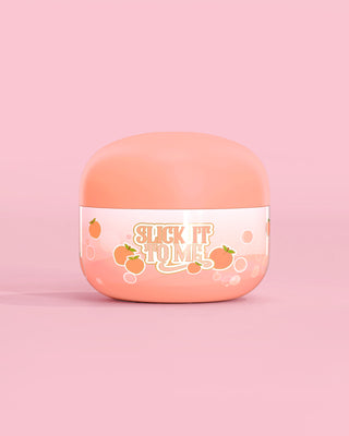 Jar of P. Louise Slick It To Me Peach Melting Body Balm s růžovým pozadím