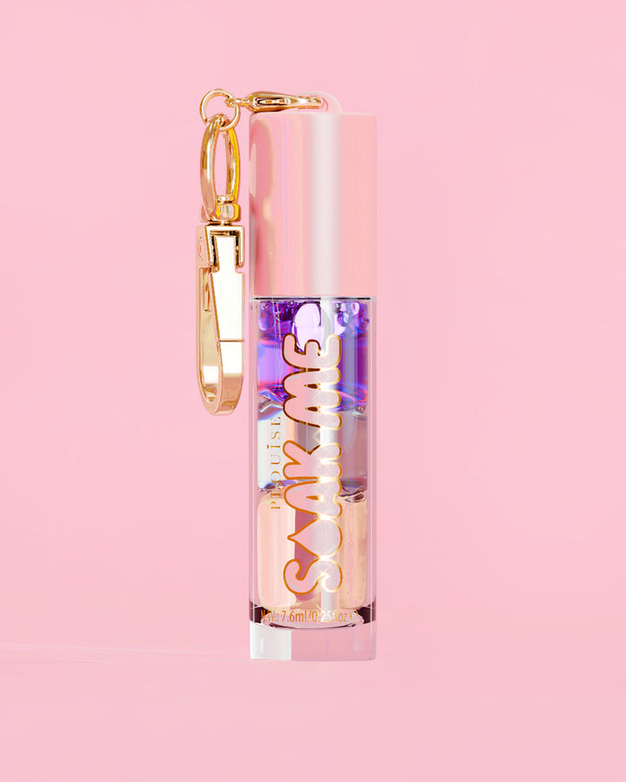 P. Louise Soak Me Lip Oil s barevným vrstveným olejem v růžové tubě se zlatou sponou na růžovém pozadí