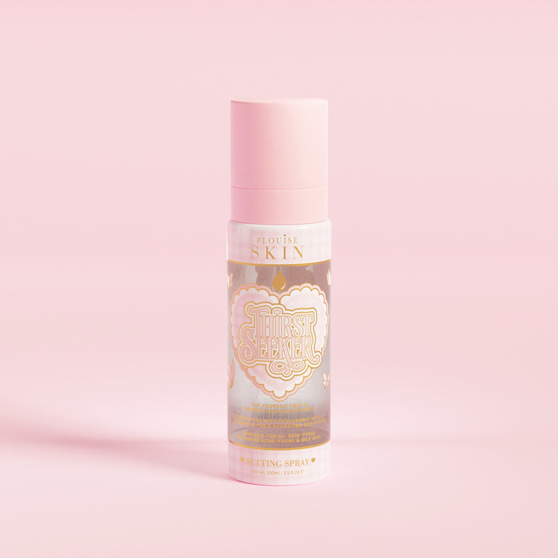 Růžová lahvička s rozprašovačem s označením 'P.Louise SKIN' s vyobrazením srdce a květinovými prvky, obsahující hydratační tužidlo ve spreji.