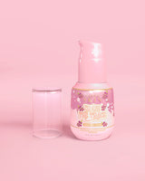 Růžová lahvička P. Louise Erase The Trace Dark Spot Correcting Serum s odklopeným víčkem na růžovém pozadí