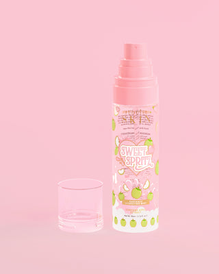 Láhev P. Louise Sweet Spritz Apple Hydrating Face Mist s uzávěrem na růžovém pozadí
