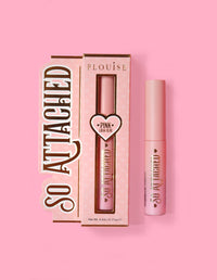 Balení produktu P.Louise So Attached Lash Glue a samotná tuba lepidla, umístěné na růžovém pozadí.