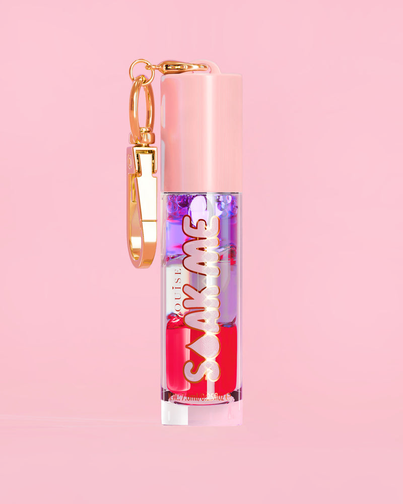 P. Louise Soak Me Lip Oil s barevným vrstveným olejem v růžové tubě se zlatou sponou na růžovém pozadí