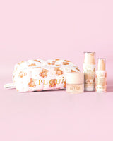Obrázek P.Louise Softest Touch Starter Kit péče o pleť s velkým potiskem medvídka s taškou na péči o pleť a make-up a 3 produkty péče o pleť na růžovém pozadí