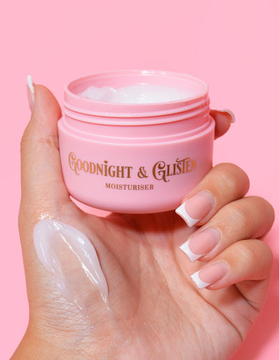 Ruka držící růžovou nádobu P.Louise Goodnight & Glisten Gel Moisturizer s trochou hydratačního krému viditelným na .and